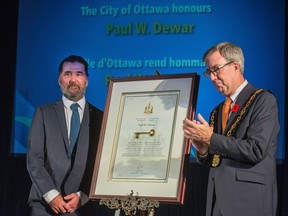 Mayor Jim Watson, right, presents the key to the city to Paul Dewar during a ceremony at Ottawa City Hall on Thursday, Nov. 1, 2018.