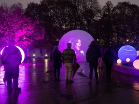 Pedestrians stop to view The Edge of Peace in Confederation Park, running every evening from dusk to 10:30 until November 11. This interactive exhibit is presented by Veterans Affairs Canada as part of Veterans' Week. The multimedia production illuminates a "moonGARDEN" of spheres to commemorate Canada's Hundred Days and the Armistice of the First World War. It honours all those who have served, and highlights the fragile nature of peace. Background: The Edge of Peace, created by Lucion Média, tells a 14-minute story (repeating every 20 minutes) through images, light and shadow, and sound. Four First World War soldiers who served during Canada's hundred days reflect on their service, while a recently bereaved composer struggles to find consolation by creating and performing her new song. Their journeys to inner peace come together through poetry, music and theatre. Photo by Wayne Cuddington/ Postmedia