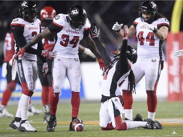 Ottawa Redblacks defensive back Sherrod Baltimore (27) celebrates an interception with teammate linebacker Kyries Hebert (34) against the Calgary Stampeders during the first half of the 106th Grey Cup at Commonwealth Stadium in Edmonton, Sunday, November 25, 2018.
