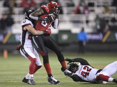 Calgary Stampeders wide receiver Chris Matthews (81) gets tackled by Ottawa Redblacks defensive back Anthony Cioffi (24) and Ottawa Redblacks linebacker Avery Williams (42) during the second half of the 106th Grey Cup at Commonwealth Stadium in Edmonton, Sunday, November 25, 2018.