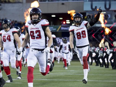 Members of the Ottawa Redblacks run onto the field prior to the first half of the 106th Grey Cup against the Calgary Stampeders in Edmonton, Alta. Sunday, Nov. 25, 2018.
