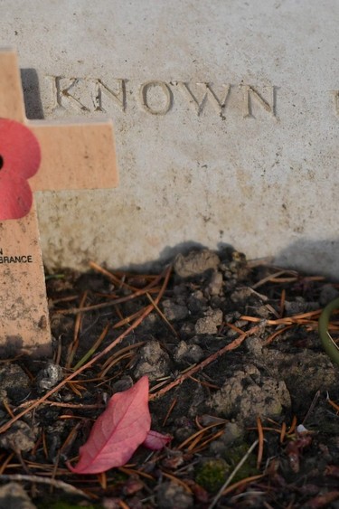 Wooden crosses and poppies adorn the grave of an unknown soldier at Saint-Symphorien Military Cemetery near Mons, Belgium, on Nov. 6, 2018.