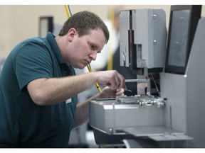 An employee at the Broward County Supervisor of Elections office cleans machines during a break in sorting ballots, Tuesday, Nov. 13, 2018, in Lauderhill, Fla.