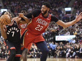 Toronto Raptors guard Kyle Lowry (7) and New Orleans Pelicans forward Anthony Davis (23) battle for the ball during first half NBA basketball action in Toronto on Monday, November 12, 2018.