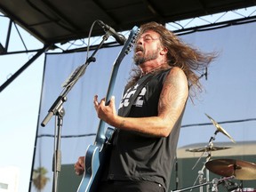 FILE - In this Aug. 26, 2018 file photo, Dave Grohl of the Foo Fighters performs at the Cal Jam 18 Pop-Up Event at the Hollywood Palladium in Los Angeles. Grohl doesn't want firefighters battling the California wildfires to go hungry. He served his Backbeat Barbeque at Fire Station 68 in Calabasas on Monday, Nov. 12, 2018. Firefighters, who have been battling the Woolsey fire, thanked Grohl on Instagram.