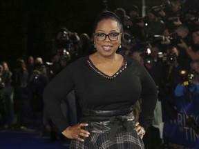 FILE - In this March 13, 2018, file photo, actress Oprah Winfrey poses for photographers upon arrival at the premiere of the film 'A Wrinkle In Time' in London. Winfrey has chosen Michelle Obama's "Becoming" as her next book club pick, The Associated Press has learned. In a statement Monday, Nov. 12, Winfrey said the memoir was "well-written" and inspirational.
