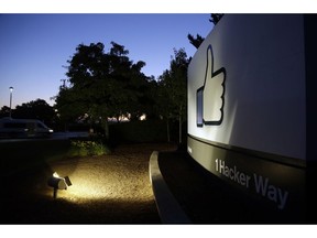 FILE- In this Jun 7, 2013, file photo, the Facebook "like" symbol is illuminated on a sign outside the company's headquarters in Menlo Park, Calif. Facebook says it is making progress on deleting hate speech, graphic violence and other violations of its rules, including detecting them before they are seen by users. The company released its second report Thursday, Nov. 15, 2018, detailing how it enforces community standards banning hate, nudity and other content.