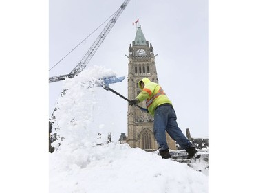 Pete Evans from CSL clears the snow on Parliament Hill after a overnight snow storm in Ottawa Friday Nov 17, 2018.