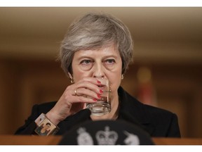 Britain's Prime Minister Theresa May takes a drink of water during a press conference inside 10 Downing Street in London, Thursday, Nov. 15, 2018. Two British Cabinet ministers, including Brexit Secretary Dominic Raab, resigned Thursday in opposition to the divorce deal struck by Prime Minister Theresa May with the EU -- a major blow to her authority and her ability to get the deal through Parliament.