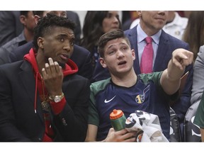 Utah Jazz's Donovan Mitchell, left, speaks with Grayson Allen, right, after he sits on the bench in the first half during an NBA basketball game against the Toronto Raptors Monday, Nov. 5, 2018, in Salt Lake City.