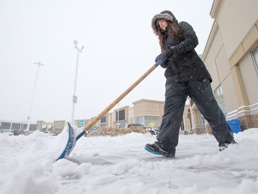 Alyssa Laflamme-Aubry clears snow in College Square as the region deals with the first significant snowfall in November.
