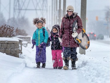 Katia Mohindra walks her children Jacinta, 6, and Rosalia, Valencia-Mohindra, 4, to Manordale School as the region deals with the first significant snowfall in November.