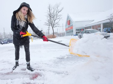 Rachael Hatoum from Loblaws, shovels snow in the College Square parking lot as the region deals with the first significant snowfall in November.