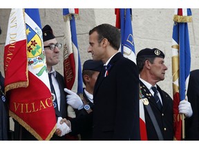 French President Emmanuel Macron greets French veterans at the cemetery by the Ossuary of Douaumont near Verdun, northeastern France, Tuesday, Nov. 6, 2018 during ceremonies marking the centenary of World War I globe.
