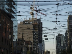 Power lines run in front of a building under construction in Toronto on Wednesday, July 11, 2018.