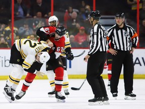 Boston Bruins centre Sean Kuraly (52) gets taken to the ice by Senators defenceman Ben Harpur during the second period in Ottawa on Sunday. (Fred Chartrand/The Canadian Press)