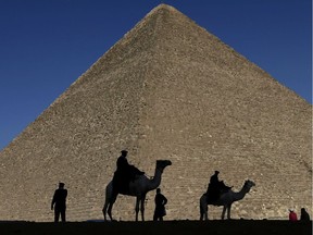 FILE - In this Dec. 12, 2012 file photo, policemen are silhouetted against the Great Pyramid in Giza, Egypt.