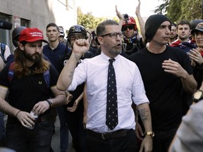 In this April 27, 2017 file photo, Gavin McInnes, center, founder of the far-right group Proud Boys, is surrounded by supporters after speaking at a rally in Berkeley, Calif.