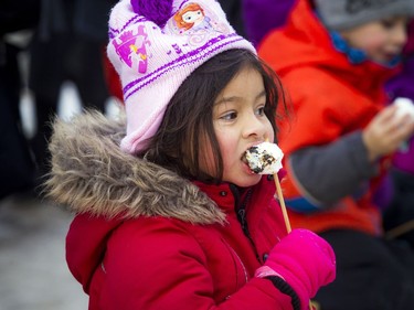 Six-year-old Salome Ruthnum Pelletier enjoys a roasted marshmallow near the bonfires.