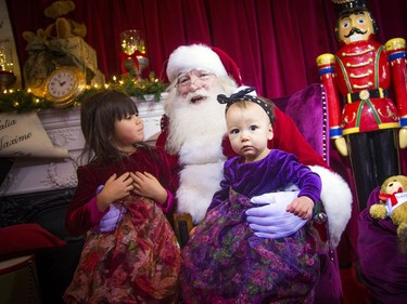 Five-year-old Thea Cormier and her ten-month-old sister Quiana visit with Santa.