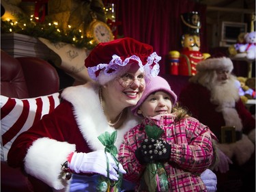 Four-year-old Allie Larocque poses for a photo with Mrs. Claus during the Christmas party at Ottawa City Hall on Saturday.
