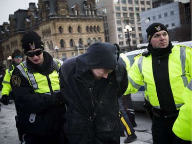 Groups opposed to Canada’s support of the UN Global Compact for Safe, Orderly and Regular Migration held a rally to protest the United Nation Global Compact for Migration while anti-fascism and anti-racism activists counter-protested, Saturday, Dec. 8, 2018 on Parliament Hill. PPS and RCMP detain an anti-fascism and anti-racism activist.  Ashley Fraser/Postmedia