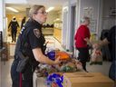 Ottawa Police Service community officer Stephanie Lemieux was one of the volunteers helping to pack food hampers at the Caldwell Family Centre on Saturday.
