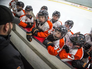 Philadelphia Little Flyers gathered at the boards to listen to the coaches.