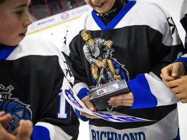 A teammate peeks at the second-star trophy presented to the Royals' Shaun McGauley for his efforts in Sunday's contest.