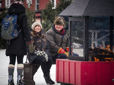The National Capital Commission launched the Rideau Canal Skateway's 49th season by opening a 2.7-kilometre section Sunday, Dec. 30, 2018. L-R NCC board members Tanya Gracie, Sara O'Neill and Victor Brunette warm beside the fire on the canal.