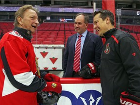 Senators owner Eugene Melnyk, left, talks with general manager Pierre Dorion, centre, and Guy Boucher during the 15th annual Eugene Melnyk Skate for Kids at the Canadian Tire Centre on Thursday, Dec. 20, 2018.