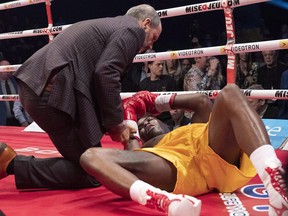 Ring doctor Marc Gagné, left, checks on Adonis Stevenson after he was knocked out by Oleksandr Gvozdyk in their WBC championship fight, Saturday, Dec. 1, 2018, in Quebec City.