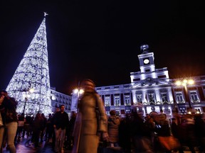 People walk past a Christmas tree at Plaza Mayor in Madrid on December 15, 2018.