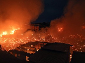 TOPSHOT - Night view of Educandos neighbourhood engulfed in flames during a massive fire in Manaus, Amazonas state, Brazil, on December 17, 2018. - According to Manaus Civil Defense Department  the fire destroyed at least 600 houses and its origin is still unknown.