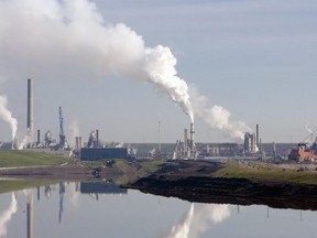 (FILES) In this file photo taken on June 14, 2007, the Syncrude extraction facility in the northern Alberta oil sand fields is reflected in the pool of water being recycled for re-use in the extraction process in Fort McMurray, Alberta, Canada. - Canada's oil sector, hurt by low prices and a lack of pipeline capacity to get its product to new overseas markets, received Can$1.6 billion (US$1.2 billion) in government aid on Tuesday, December 18, 2018. The federal monies include direct aid and export development loans to help the sector "diversify export markets for its resources beyond the United States," according to a statement.