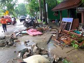 Debris from damaged buildings is seen on a street on Carita beach on Sunday, Dec. 23, 2018, after the area was hit by a tsunami on Dec. 22.