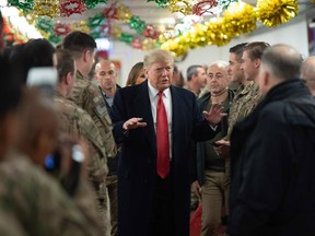 US President Donald Trump greets members of the US military during an unannounced trip to Al Asad Air Base in Iraq on December 26, 2018. - President Donald Trump arrived in Iraq on his first visit to US troops deployed in a war zone since his election two years ago