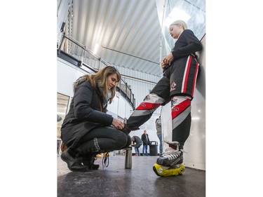 Isabelle Keil ties the skates of her daughter Samantha Keil of the Nepean Wildcats in the Girls Atom AA division before playing against the Whitby Wolves as the annual Bell Capital Cup hockey tournament for Peewee and Atom level players gets underway at the Bell Sensplex and various arenas across the city.