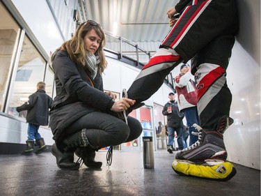 Isabelle Keil ties the skates of her daughter Samantha Keil of the Nepean Wildcats in the Girls Atom AA division before playing against the Whitby Wolves as the annual Bell Capital Cup hockey tournament for Peewee and Atom level players gets underway at the Bell Sensplex and various arenas across the city.