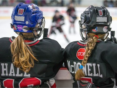 Molly Hale and Annie McDonnell (R) of the Nepean Wildcats in the Girls Atom AA division watch action against the Whitby Wolves as the annual Bell Capital Cup hockey tournament for Peewee and Atom level players gets underway at the Bell Sensplex and various arenas across the city.