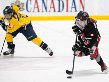 Jordan Mulvihill of the Nepean Wildcats in the Girls Atom AA division skates past Zoe Ordanis of the Whitby Wolves as the annual Bell Capital Cup hockey tournament for Peewee and Atom level players gets underway at the Bell Sensplex and various arenas across the city.