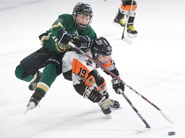 David Ambuhl of the Minor Peewee AA Clifton Park Dynamo team (R) upends Lukas Murphy of the Gloucester Rangers as the annual Bell Capital Cup hockey tournament for Peewee and Atom level players gets underway at the Bell Sensplex and various arenas across the city.