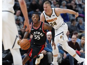 Toronto Raptors guard Delon Wright, drives past Denver Nuggets forward Mason Plumlee in the first half of an NBA basketball game Sunday, Dec. 16, 2018, in Denver.