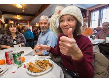 Christine Thomson gives a thumbs up on the food as the annual Carleton Tavern Christmas Dinner was held from 11am to 3pm with about 120 volunteers taking turns serving meals to anyone who wanted to come in and enjoy some company, live music and roast turkey with all the trimmings including dessert.  Photo by Wayne Cuddington/ Postmedia