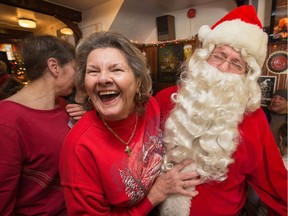 Anna Halchuk throws Santa for a loop when she asks him for a man as the annual Carleton Tavern Christmas Dinner was held from 11am to 3pm with about 120 volunteers taking turns serving meals to anyone who wanted to come in and enjoy some company, live music and roast turkey with all the trimmings including dessert.  Photo by Wayne Cuddington/ Postmedia