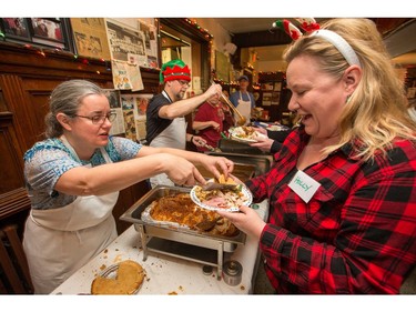 Volunteers Holly Lake gets a plate of food from Jeanette Rule to deliver to a patron as the annual Carleton Tavern Christmas Dinner was held from 11am to 3pm with about 120 volunteers taking turns serving meals to anyone who wanted to come in and enjoy some company, live music and roast turkey with all the trimmings including dessert.  Photo by Wayne Cuddington/ Postmedia