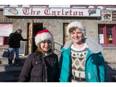 Young volunteers Demeter Riedmueller, 12, and Artemis Reidmueller, 14, head home after helping out as the annual Carleton Tavern Christmas Dinner was held from 11am to 3pm with about 120 volunteers taking turns serving meals to anyone who wanted to come in and enjoy some company, live music and roast turkey with all the trimmings including dessert.  Photo by Wayne Cuddington/ Postmedia