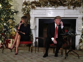 President Donald Trump and first lady Melania Trump each speak on the phone sharing updates to track Santa's movements from the North American Aerospace Defense Command (NORAD) Santa Tracker on Christmas Eve, Monday, Dec. 24, 2018.