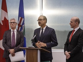 Canada's Minister of International Trade Diversification Jim Carr, left, Canada's Minister of Natural Resources Amarjeet Sohi, centre and Randy Boissonnault, Edmonton M.P. speak during press conference to announce support for Canada's oil and gas sector, in Edmonton on Tuesday, Dec. 18, 2018.