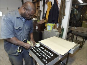 In this Dec. 11, 2018 photo, Monument Center, Inc. of Ferndale sand blaster Mike Daniels removes a rubber stencil from the granite face of the headstone of Kenneth "KJ" Gross, at the center in Ferndale, Mich. Kaleb Klakulak, a 12-year-old Michigan boy who'd been working odd jobs to raise money for a gravestone for his best friend is getting his wish, thanks to a funeral home owner's generosity. (Todd McInturf/Detroit News via AP) ORG XMIT: MIDTN202